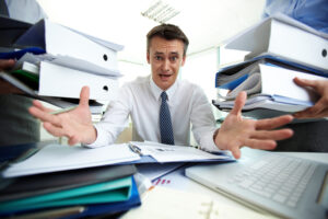 sticky notes, scattered papers, and a cluttered desk, symbolizing a lack of effective business systems and processes