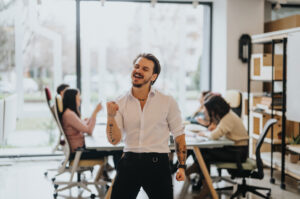 A cheerful entrepreneur sitting at a tidy desk, celebrating the completion of tasks with a fist pump